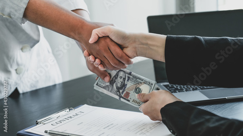 Foto Hands shaking after government officials receiving bribe money from businesswoma