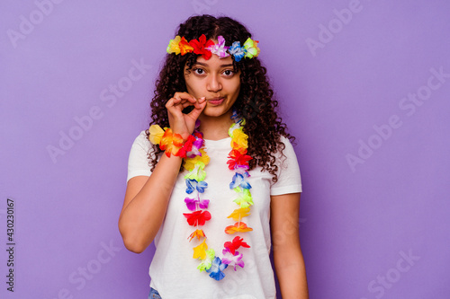 Young Hawaiian woman isolated on purple background with fingers on lips keeping a secret.