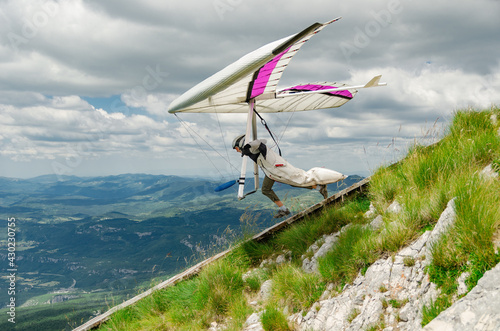 Foto Hang glider pilots runs from steep slope high in the mountains in Uchka, Croatia
