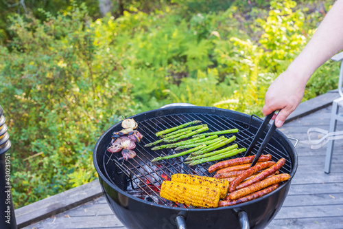 Close up view of man's hands grilling food on coal grill. Sweden. photo