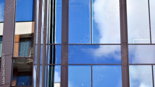 Modern office building detail  glass surface on a clear sky background. Transparent glass wall of office building.  