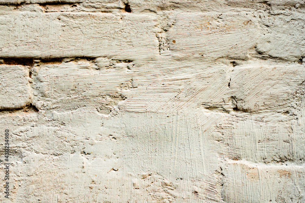 Fototapeta premium Texture of a brick wall with cracks and scratches which can be used as a background