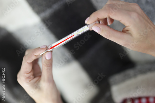 In women s hands a thermometer with temperature of 38.