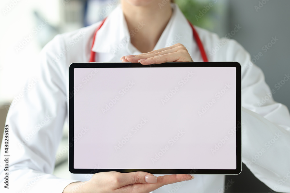 Female doctor is holding tablet with white screen Female doctor is holding tablet with white screen