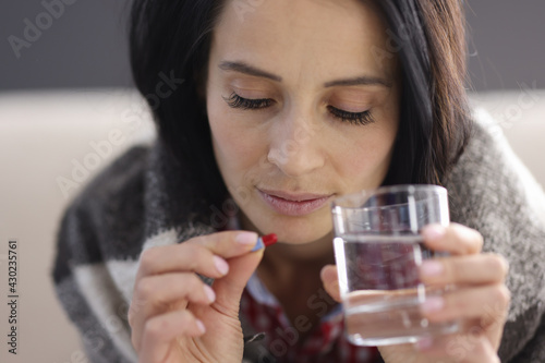 Portrait of woman with pill and glass of water.