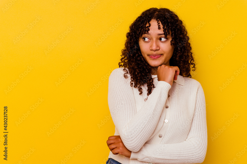 Young mixed race woman isolated on yellow background confused, feels doubtful and unsure. Young mixed race woman isolated on yellow background confused, feels doubtful and unsure.