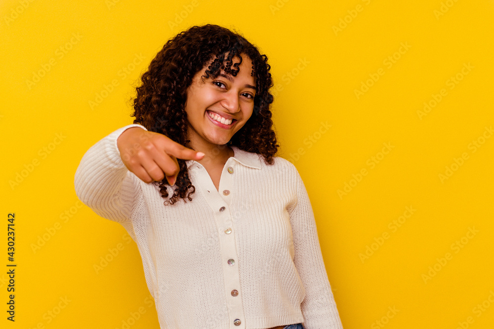 Young mixed race woman isolated on yellow background cheerful smiles pointing to front. Young mixed race woman isolated on yellow background cheerful smiles pointing to front.