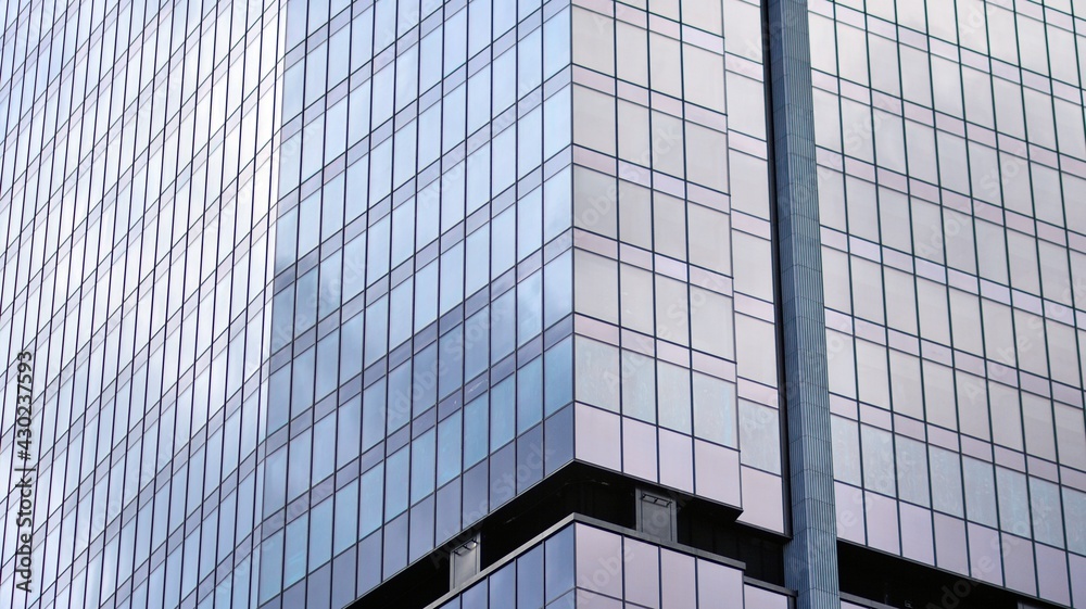 Modern office building detail, glass surface on a clear sky background. Transparent glass wall of office building. Modern office building detail, glass surface on a clear sky background. Transparent glass wall of office building.