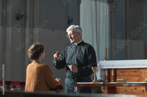 Εκτύπωση καμβά Senior priest blessing the faithful woman in the church