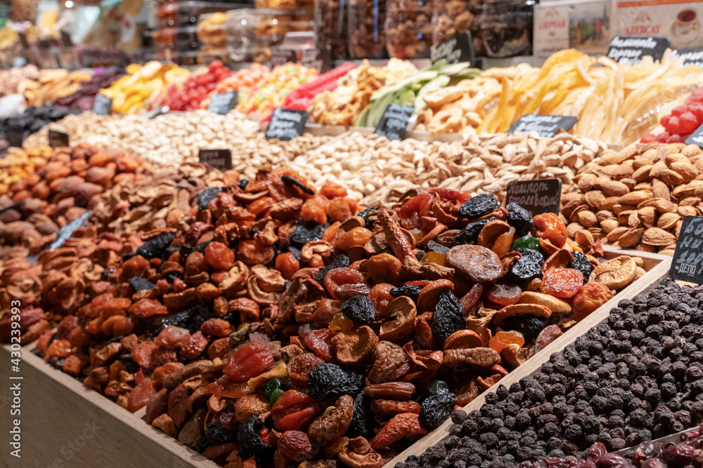 Market counter with various assorted dried fruits and nuts. Healthy food. Local market place.
