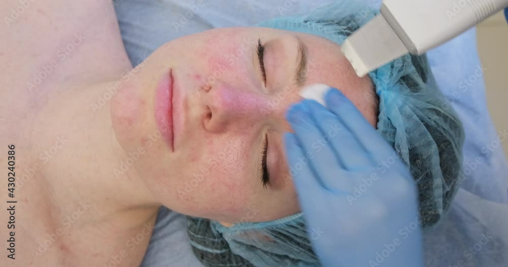 Young woman in a beauty salon, beautician makes ultrasonic cleaning of the skin of the face. Young woman in a beauty salon, beautician makes ultrasonic cleaning of the skin of the face.