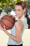 happy young woman lying on the basketball field