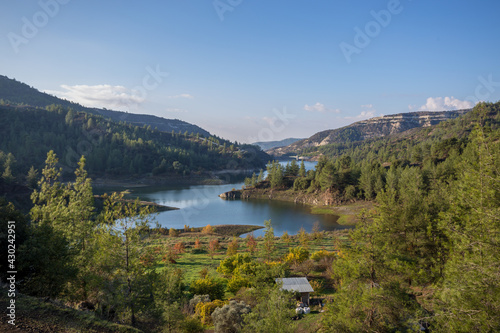 Beautiful landscape with mountains and lake. Turquoise water and beautiful winding shores with coniferous forests against the blue sky. Cyprus