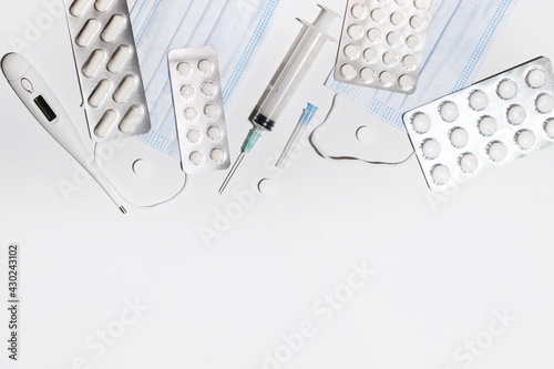 medical masks, tablets, thermometer on a white background
