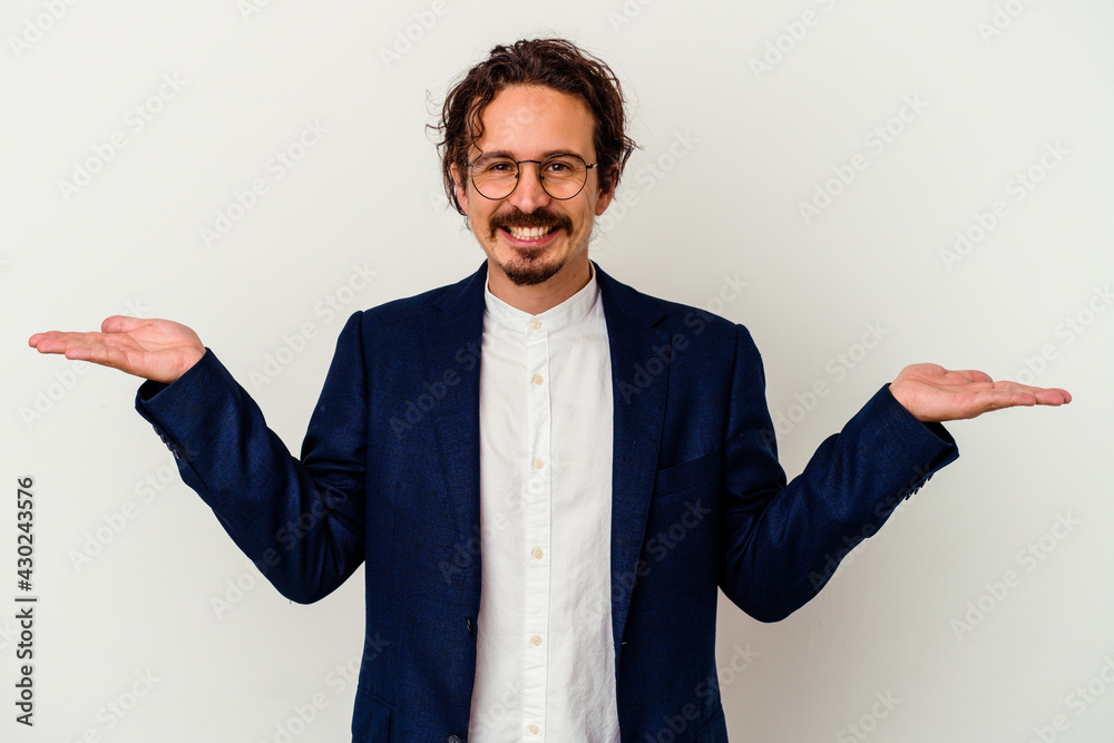 Young business man isolated on white background makes scale with arms, feels happy and confident. Young business man isolated on white background makes scale with arms, feels happy and confident.