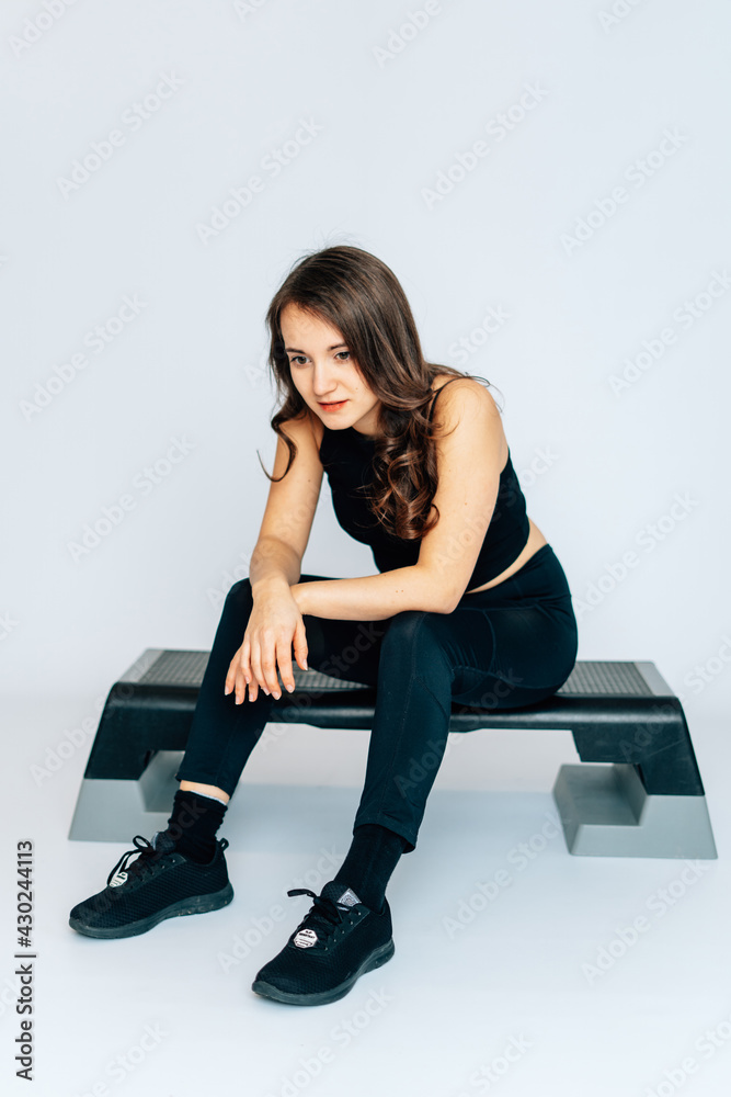 Fitness Frau sportlich sitzt auf Stepboard Bauchfrei, Fitnessstudio, Isoliert Weißer Hintergrund, verzweifelt, Corona, Covid-19, Betretungsverbot, kein Sport, ausgelaugt, keine Lust Fitness Frau sportlich sitzt auf Stepboard Bauchfrei, Fitnessstudio, Isoliert Weißer Hintergrund, verzweifelt, Corona, Covid-19, Betretungsverbot, kein Sport, ausgelaugt, keine Lust
