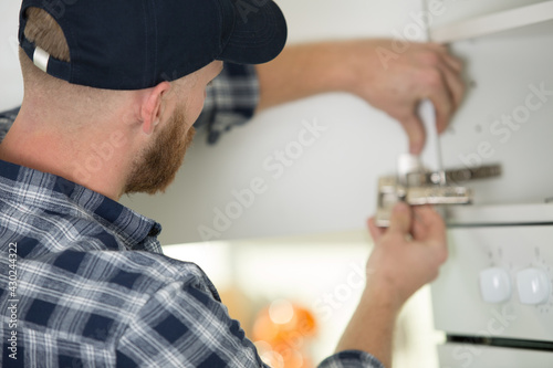 handyman is fixing the cupboard
