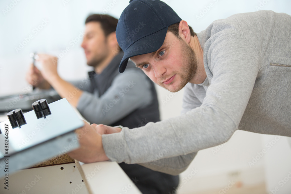 Obraz premium serviceman installing an electric hob