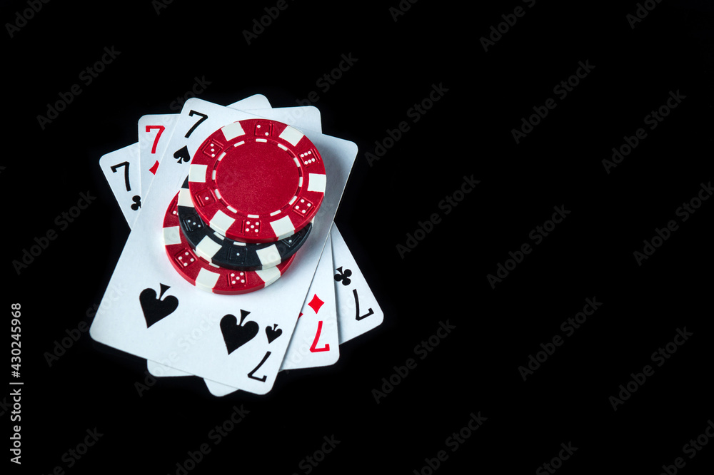 Obraz premium Poker game with a three of a kind or set combination. Chips and cards on the black table in poker club. Free advertising space