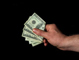 Hand holds dollars on black isolated background. Idea of success and wealth. Business and finance