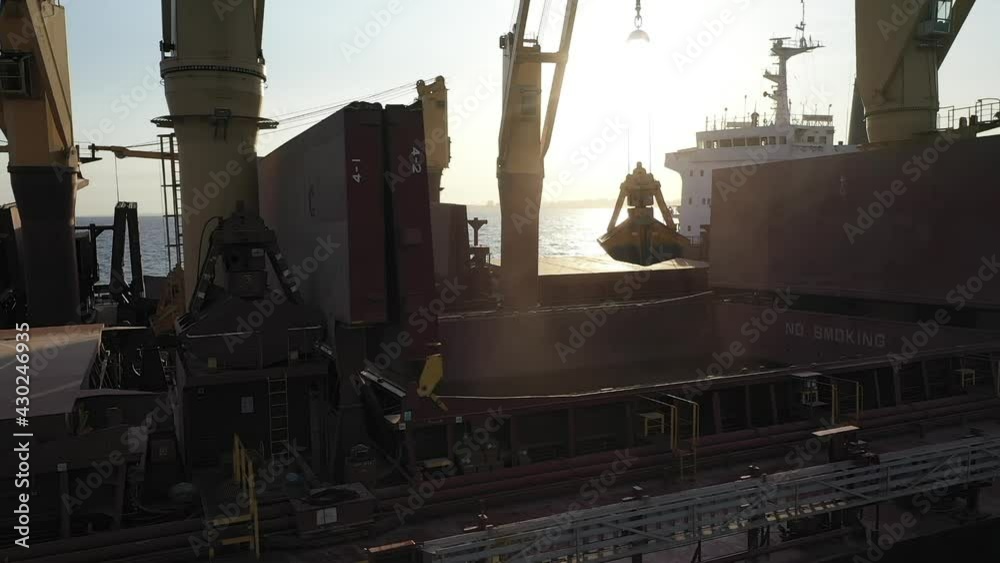 Slow-motion of underway ship to ship transfer operation, STS in open sea. Two cargo freighters anchored in morning, gantry crane load bulker with soybean, grain. Logistics and industrial sea trading Slow-motion of underway ship to ship transfer operation, STS in open sea. Two cargo freighters anchored in morning, gantry crane load bulker with soybean, grain. Logistics and industrial sea trading