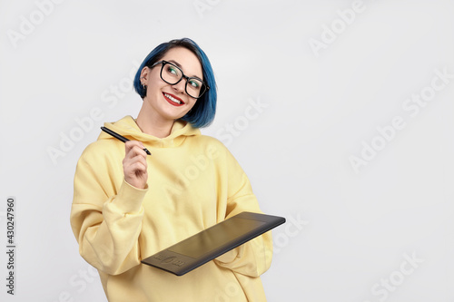 A female designer in yellow hoody holding graphic tablet