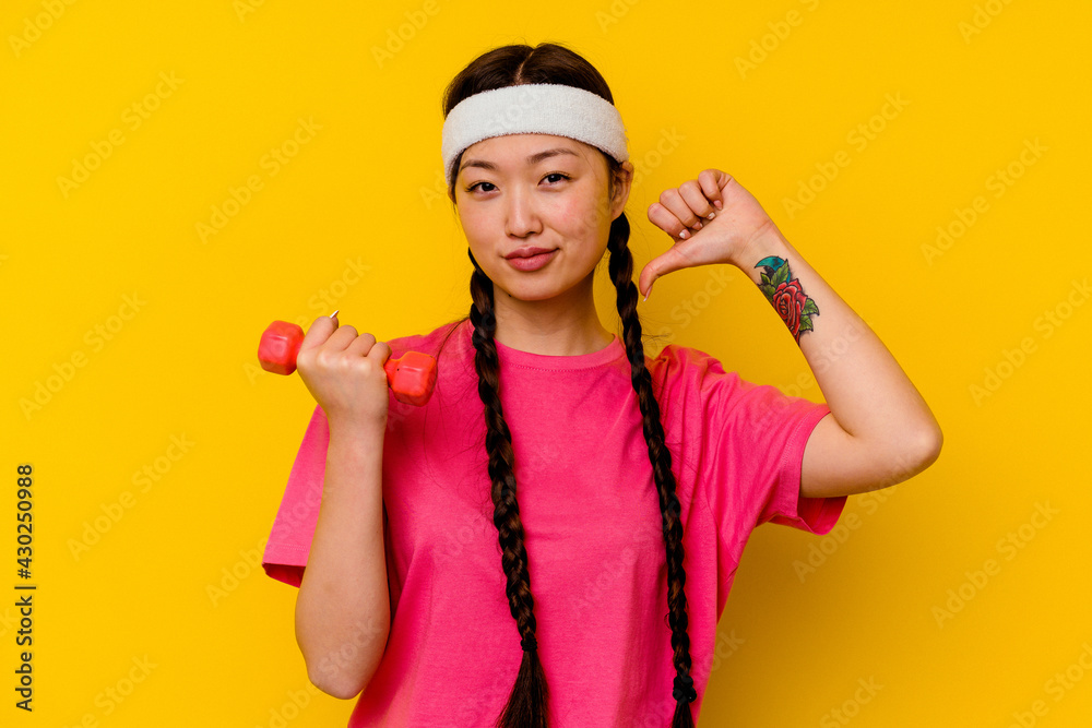 Young sport chinese woman isolated on yellow background feels proud and self confident, example to follow. Young sport chinese woman isolated on yellow background feels proud and self confident, example to follow.