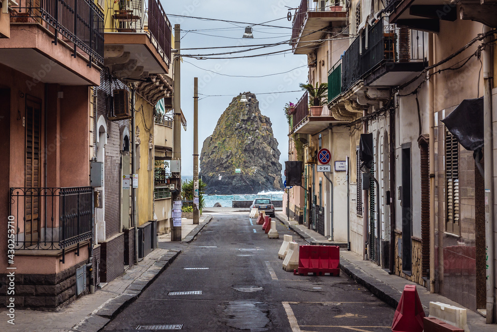One of the Cyclopean Isles seen from street in Aci Trezza township on Sicily Island, Italy