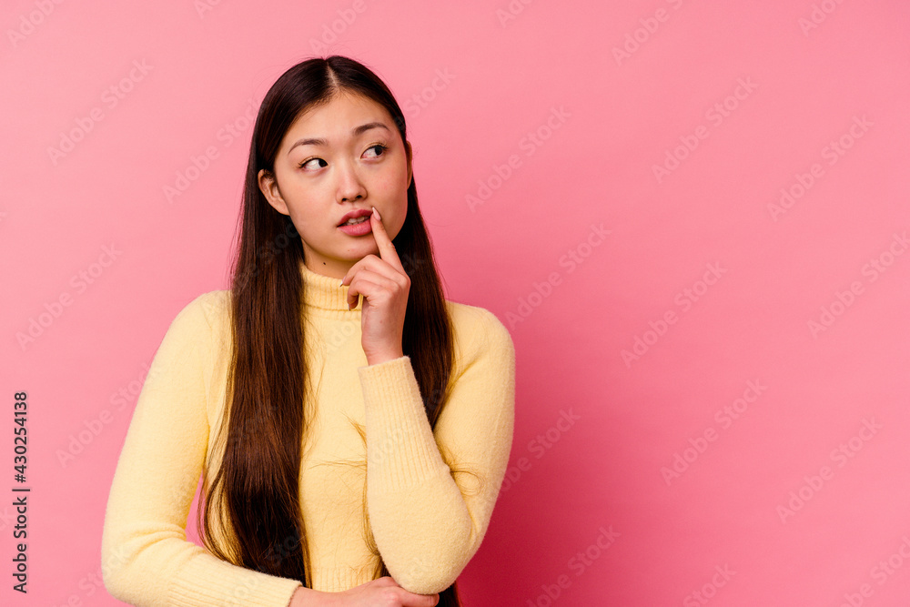 Young chinese woman isolated on pink background looking sideways with doubtful and skeptical expression. Young chinese woman isolated on pink background looking sideways with doubtful and skeptical expression.