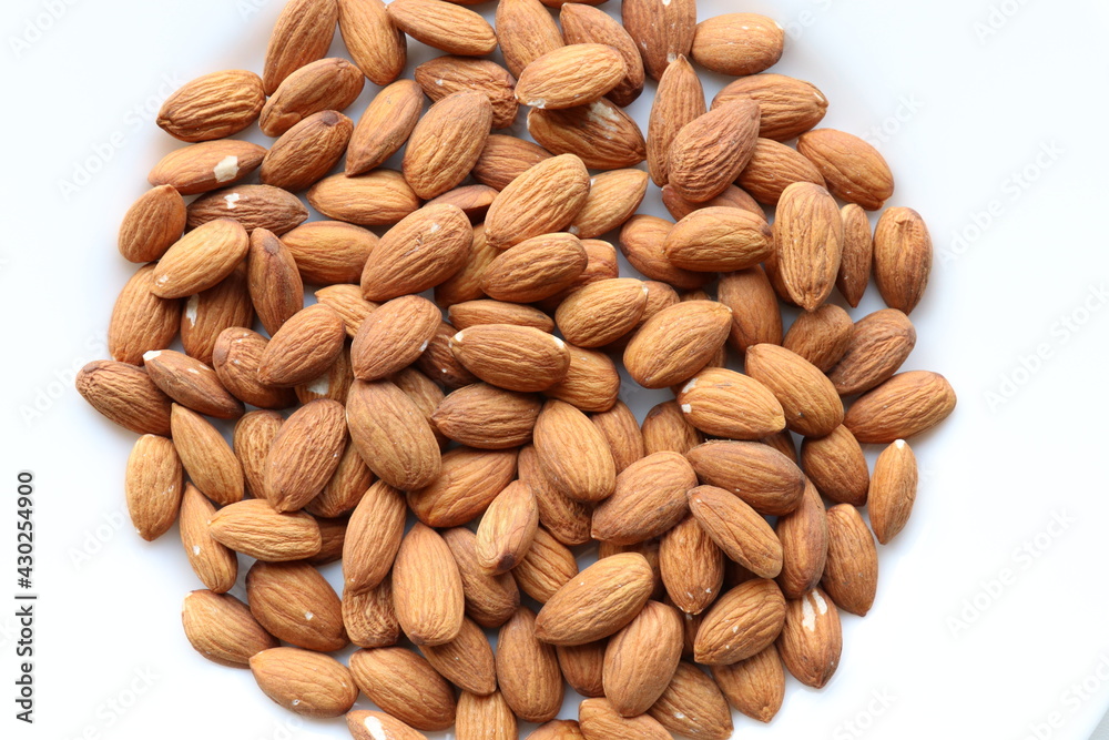 Top view of almond nuts on white plate.Healthy snack Top view of almond nuts on white plate.Healthy snack