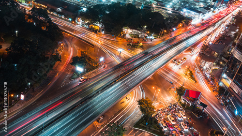 Fototapeta Naklejka Na Ścianę i Meble -  Car traffic transportation on road, bridge at junction intersection in Asia urban city, night cityscape high angle view, long exposure light trail. Asian city life, people transport lifestyle concept