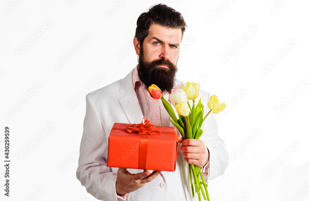 Businessman with gift and bouquet of tulips. Handsome man with present and flowers. Birthday, Valentines Day, Womens Day. Businessman with gift and bouquet of tulips. Handsome man with present and flowers. Birthday, Valentines Day, Womens Day.