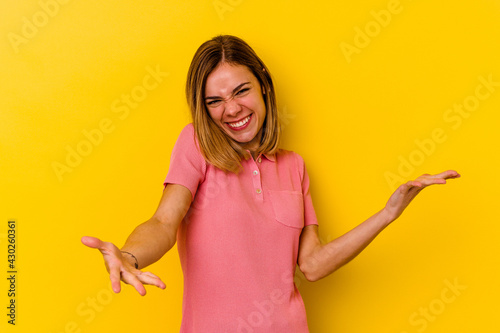 Young caucasian skinny woman isolated on yellow background showing a welcome expression.