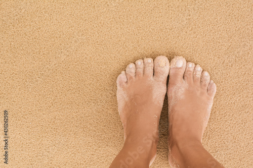 Middle age woman barefoot tanned foot and ankle deep standing on perfect sand in bright summer day copy space ecology meditation content Australia Queensland Mooloolaba beach