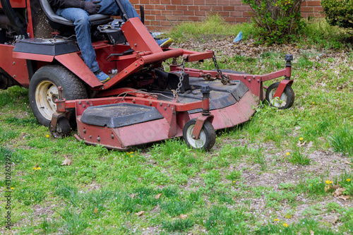Machine for cutting lawns on lawn mower on green grass in garden.