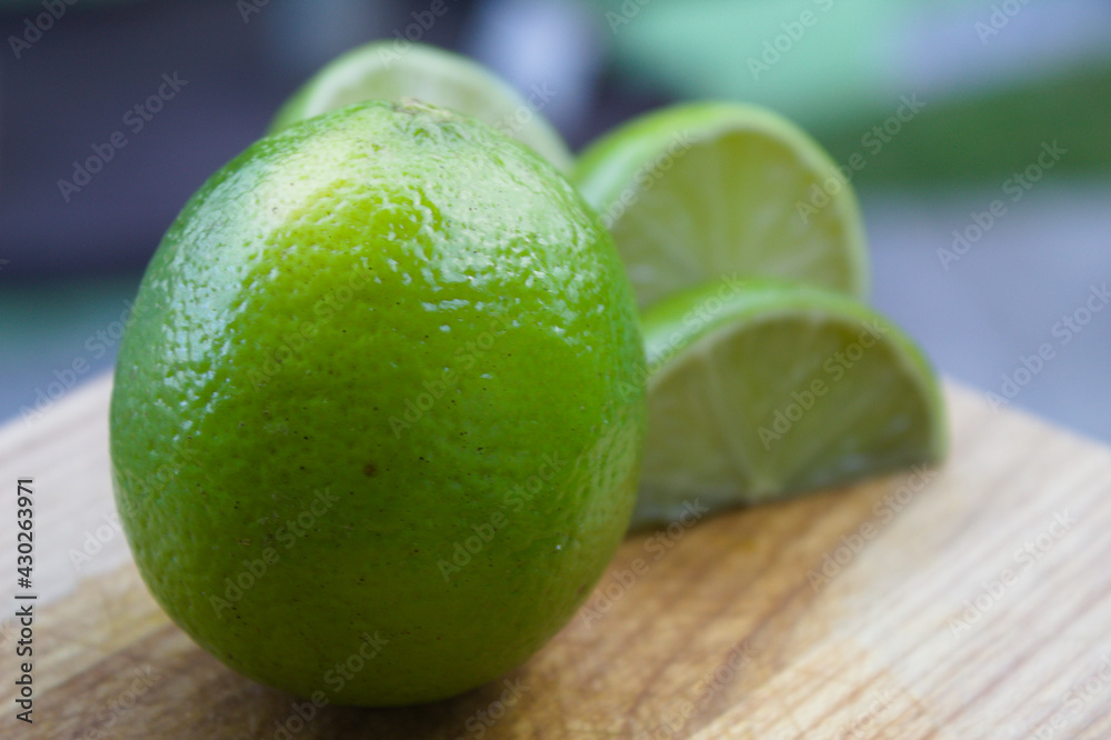 Whole lemon with some slices on a wooden board Whole lemon with some slices on a wooden board