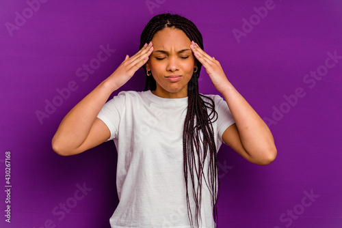 Young african american woman isolated on yellow background having a head ache, touching front of the face.