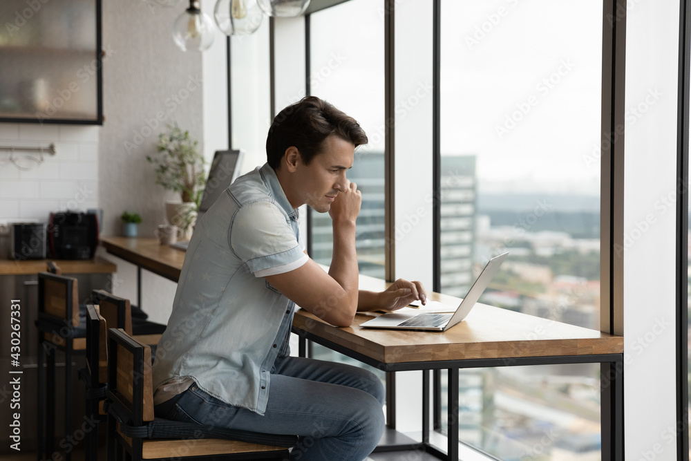 Focused young Caucasian male worker use laptop in modern office type consult client customer online. Serious man employee work distant browsing surfing on computer at workplace. Technology concept. Focused young Caucasian male worker use laptop in modern office type consult client customer online. Serious man employee work distant browsing surfing on computer at workplace. Technology concept.