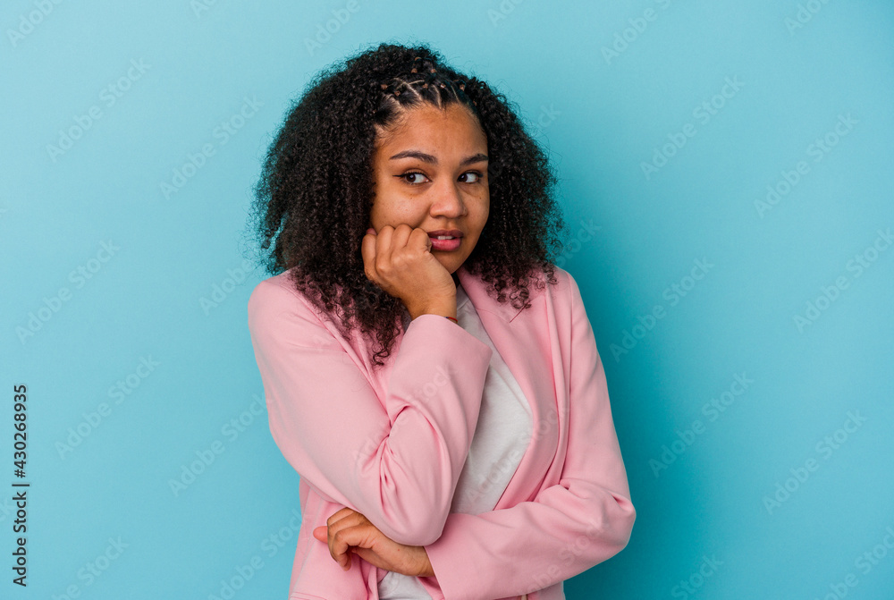 Obraz premium Young african american woman isolated on blue background biting fingernails, nervous and very anxious.