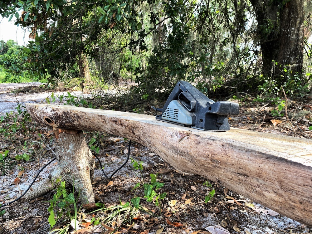 Sanding machine being used to sand down a handmade wooden bench for an outdoor park. Industrial work. Sanding machine being used to sand down a handmade wooden bench for an outdoor park. Industrial work.