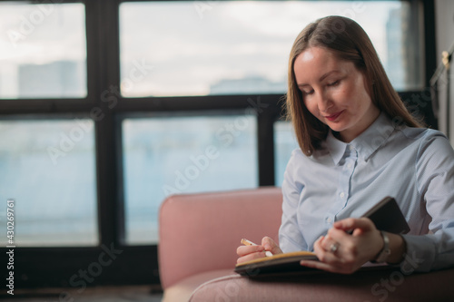 Business woman portrait in modern office interior by the window. Woman in business, portrait of a businesswoman.