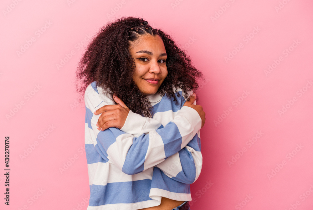 Young african american woman isolated on pink background hugs, smiling carefree and happy. Young african american woman isolated on pink background hugs, smiling carefree and happy.
