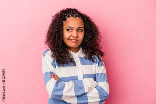 Young african american woman isolated on pink background dreaming of achieving goals and purposes