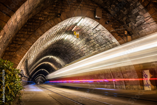 Obraz na płótnie Illuminated Tramway Tunnel with Tram Light Trails at Night in Bratislava, Slovakia w salonie