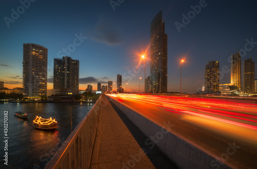 Obraz na płótnie Skyscrapers and Traffic Light Trails on Taksin Bridge Crossing Chao Phraya River in Bangkok, Thailand at Twilight w salonie