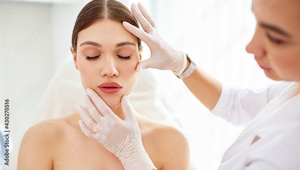 Cosmetologist in gloves checking face of woman - obrazy, fototapety, plakaty 