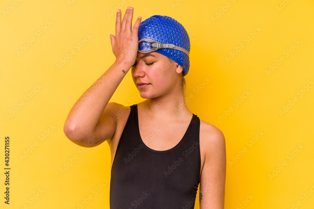 Young swimmer venezuelan woman isolated on yellow background forgetting something, slapping forehead with palm and closing eyes. Young swimmer venezuelan woman isolated on yellow background forgetting something, slapping forehead with palm and closing eyes.
