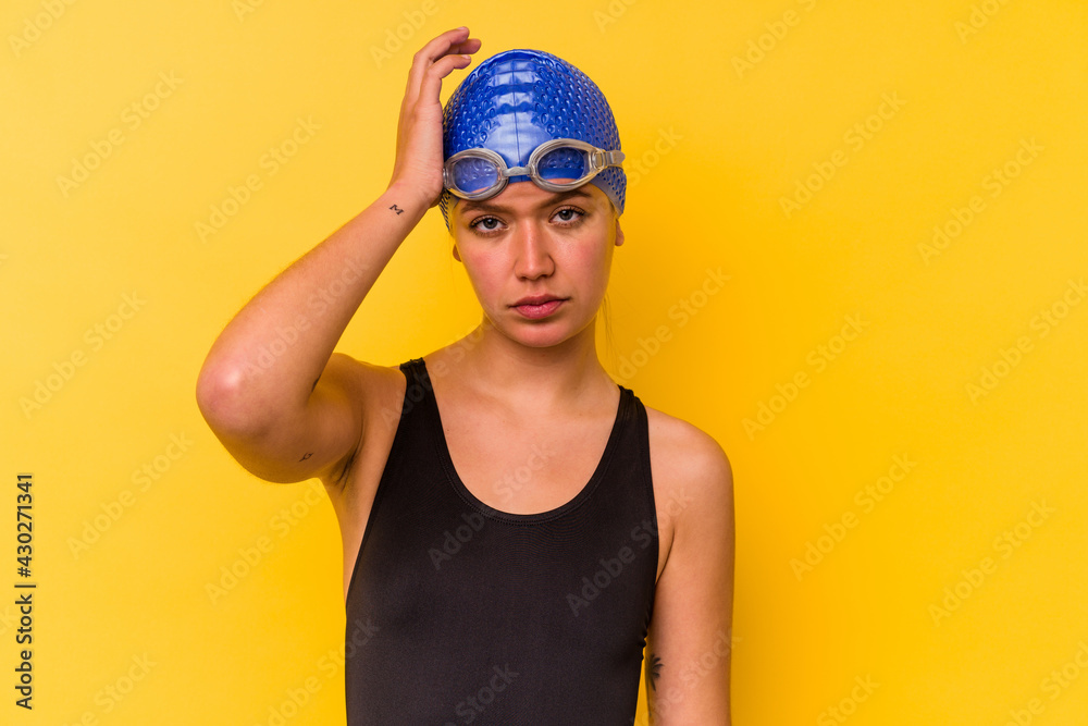 Young swimmer venezuelan woman isolated on yellow background tired and very sleepy keeping hand on head. Young swimmer venezuelan woman isolated on yellow background tired and very sleepy keeping hand on head.