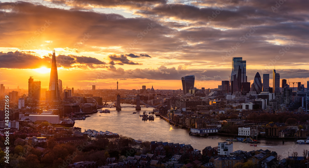 Elevated, panoramic view to the modern skyline of London from the Tower Bridge to the skyscrapers of the City during a colorful sunset, United Kingdom