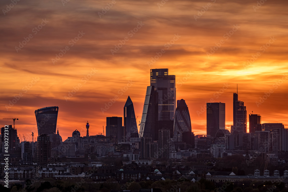 Colorful sunset behind the modern skyline with the diverse, corporate skyscrapers of the City of London, United Kingdom